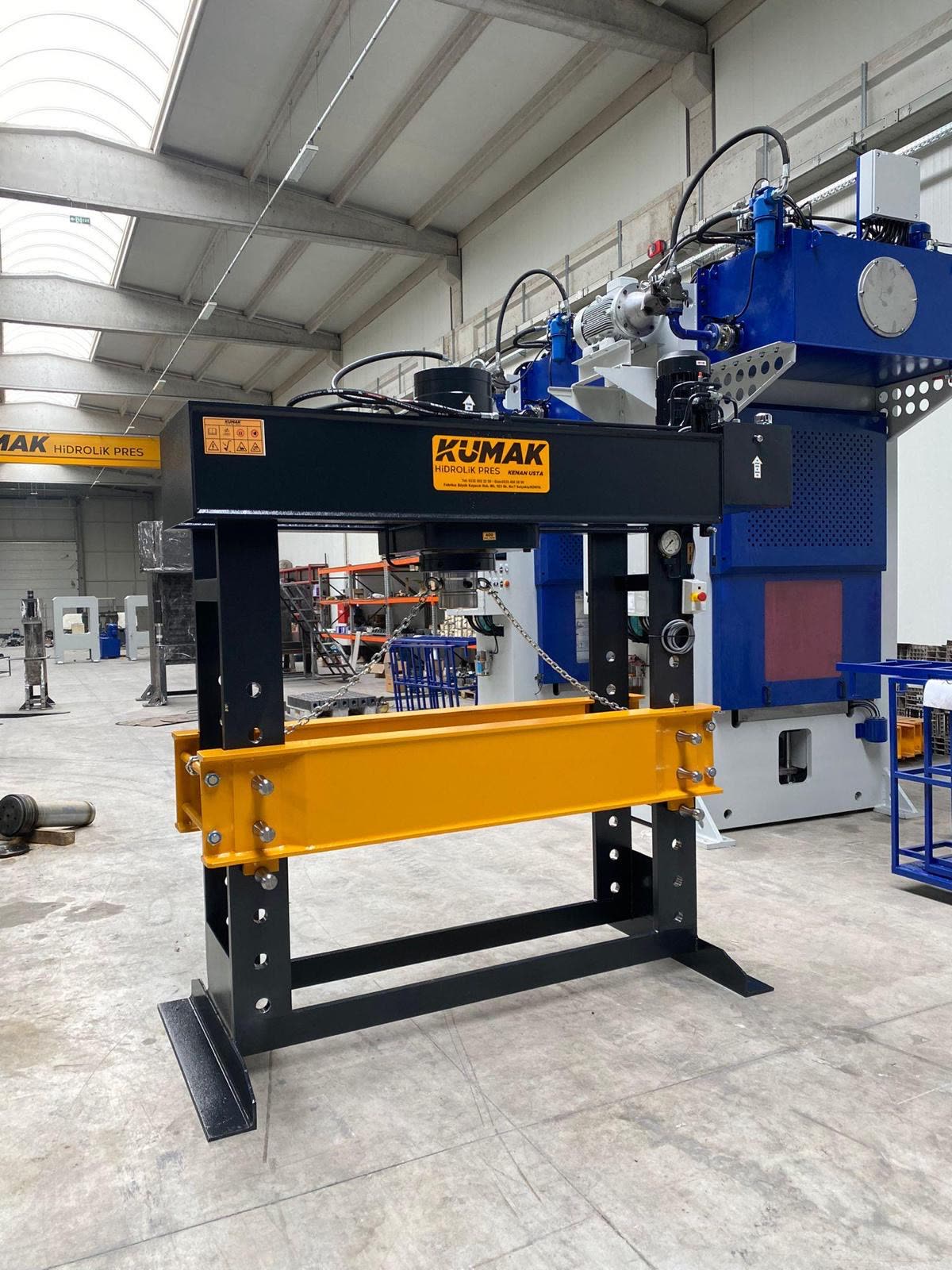 Prasa hydrauliczna Kumak w hali produkcyjnej, w tle wielkogabarytowe prasy